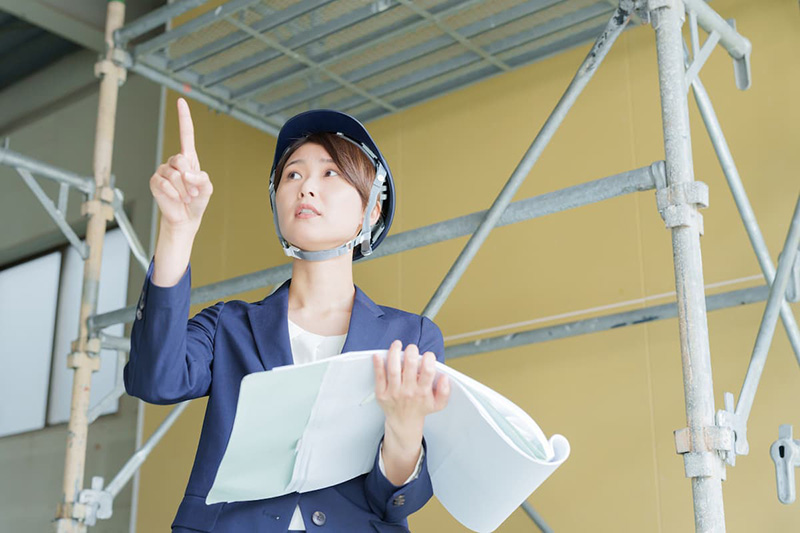 建物を検査する建築基準適合判定資格者の女性